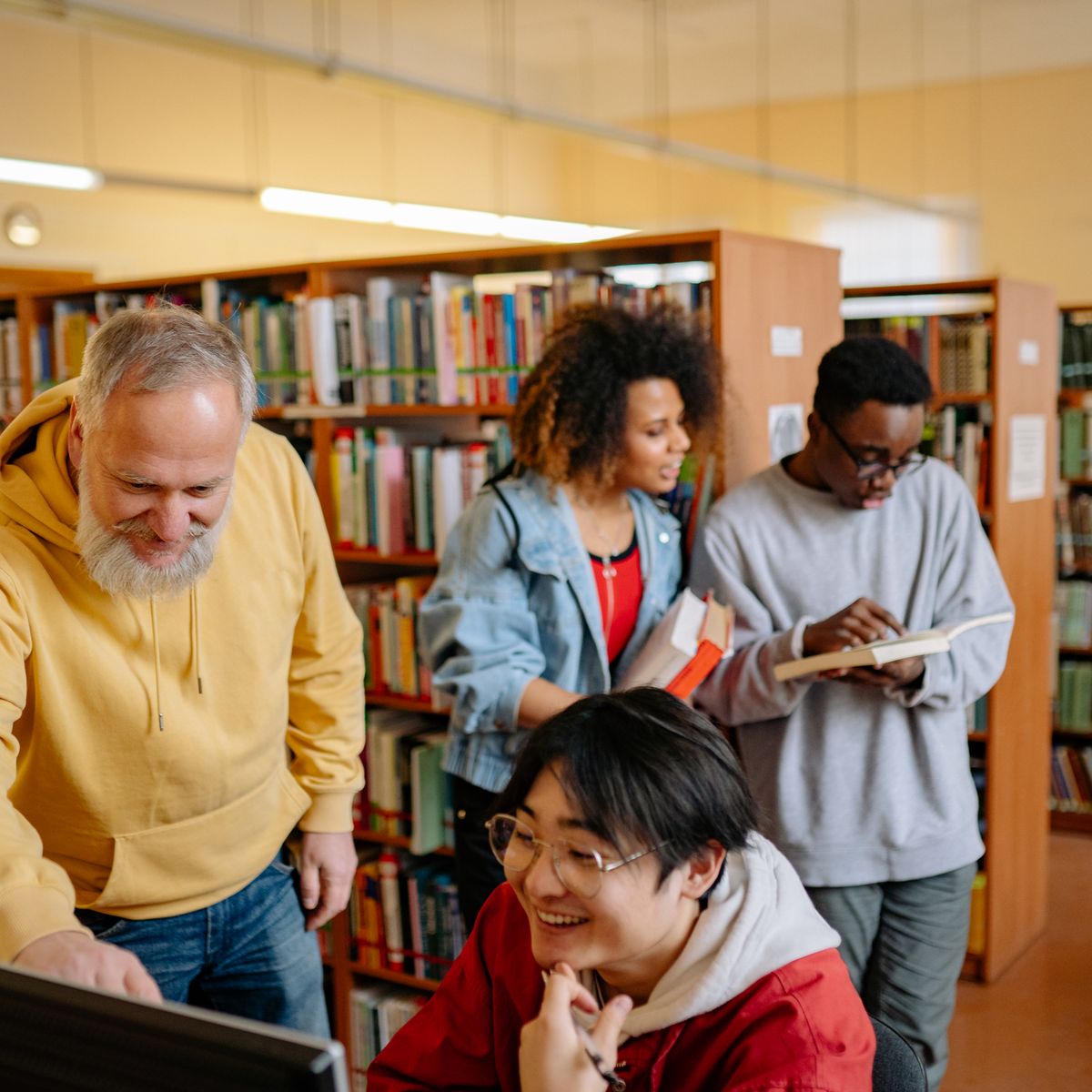 Petit groupe et un intervenant travaillant ensemble autour d'une table dans une bibliothèque